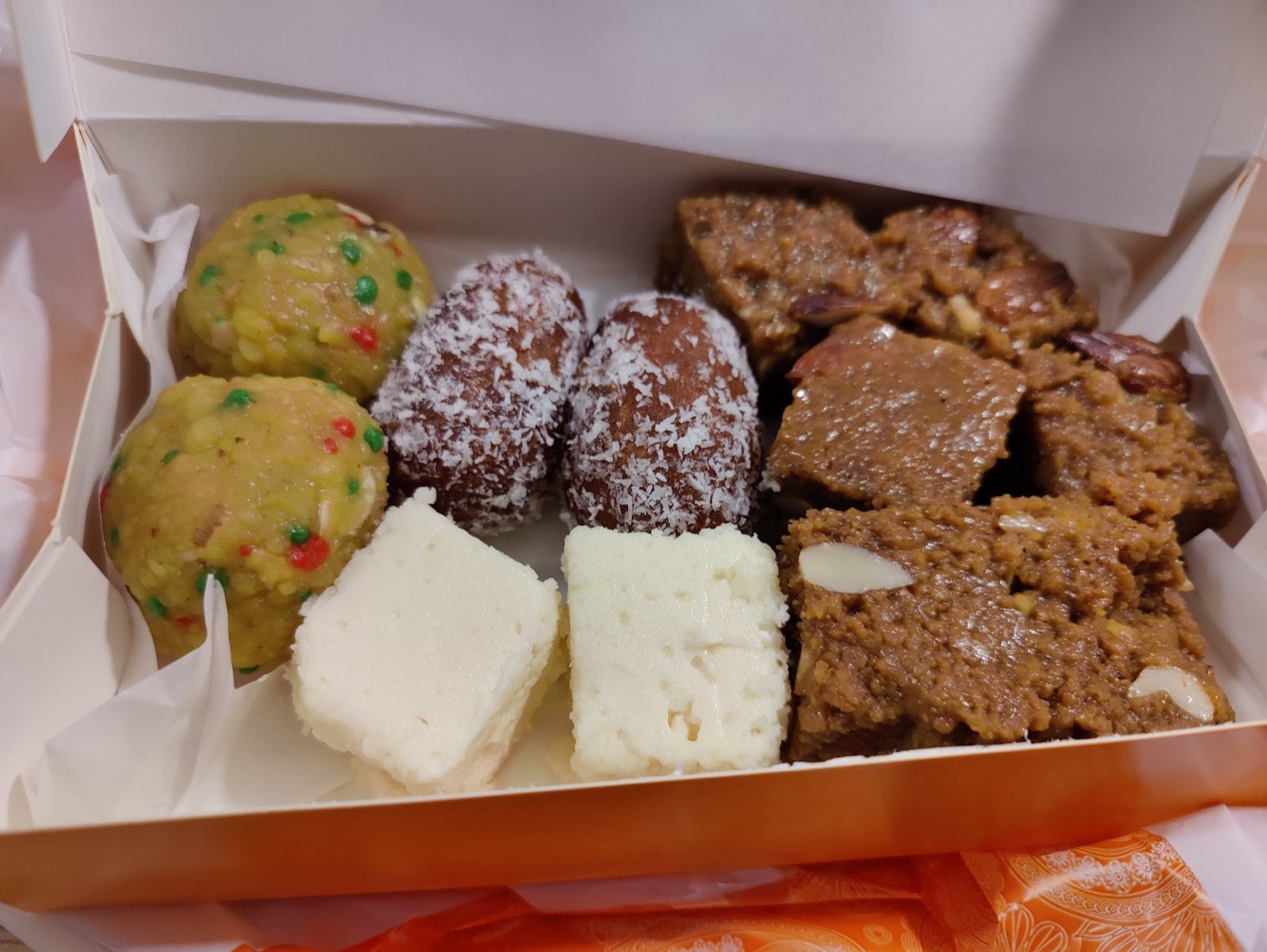 A gift box of assorted Pakistani mithai from Original Gourmet — ladoo, coconut-rolled sweets, barfi and almond halwa